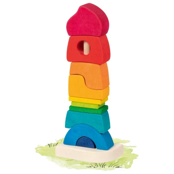 Colorful wooden stacking castle toy with various shapes balanced on a wooden base for creative play and sorting.