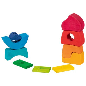 Colorful wooden stacking blocks arranged in a castle shape and spread out on a white background