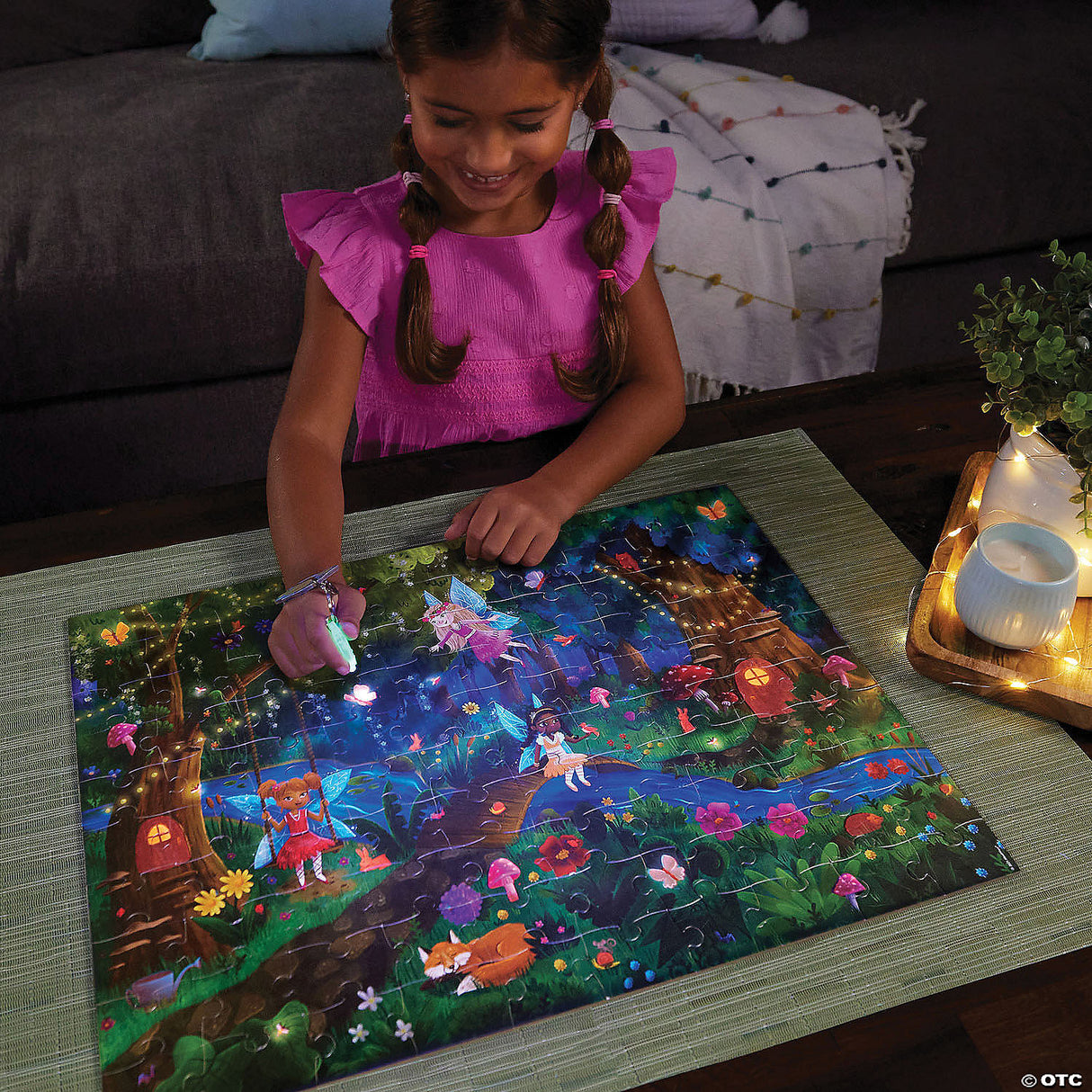 Young girl using reveal light to find hidden items on the PZ 100pc Seek&Find Fairies puzzle scene.