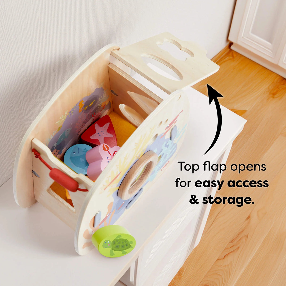 Wooden underwater shape sorter toy with top flap open showing colorful sea creature blocks inside for easy access.