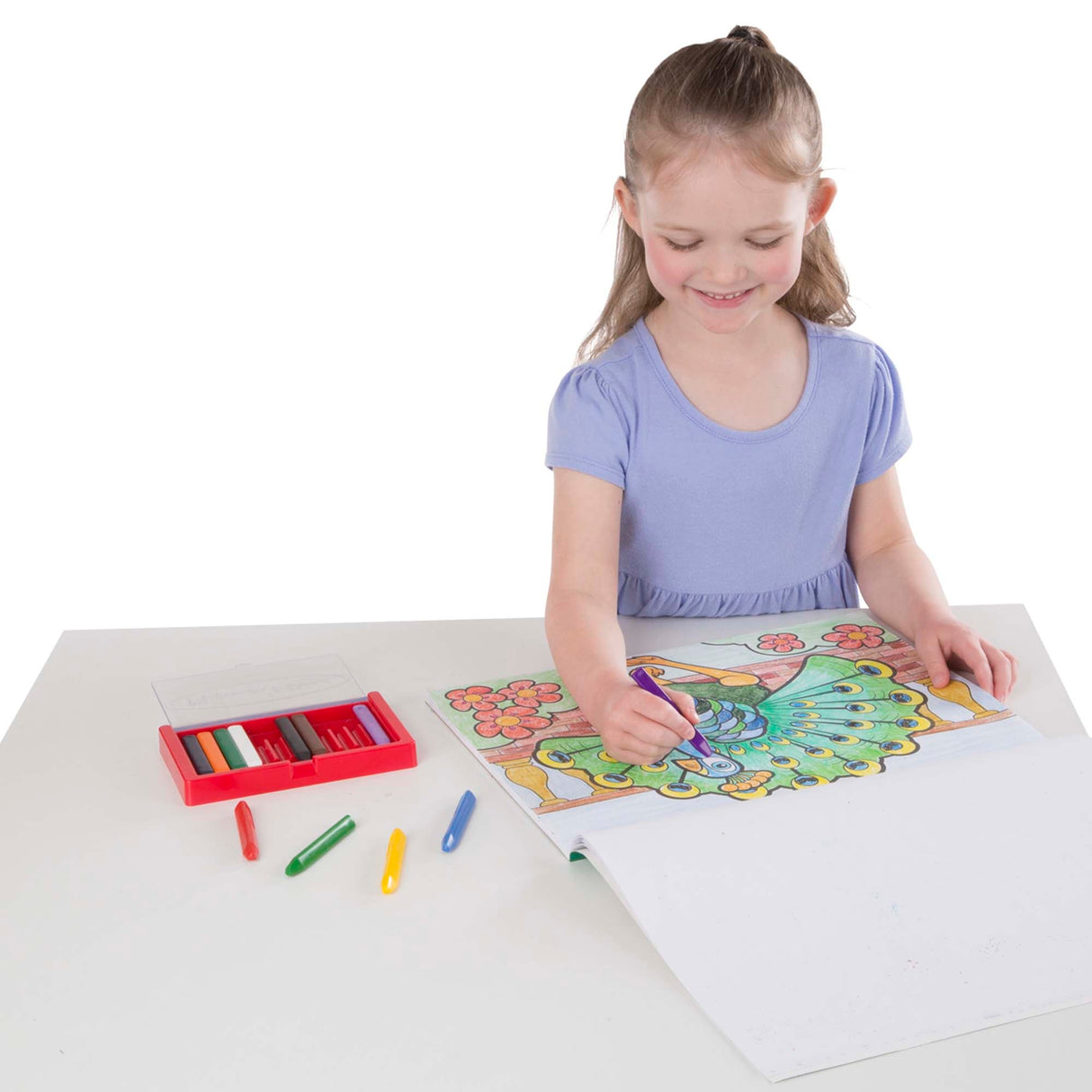 Child coloring a peacock page using crayons from the Animals Coloring Book on a white table.