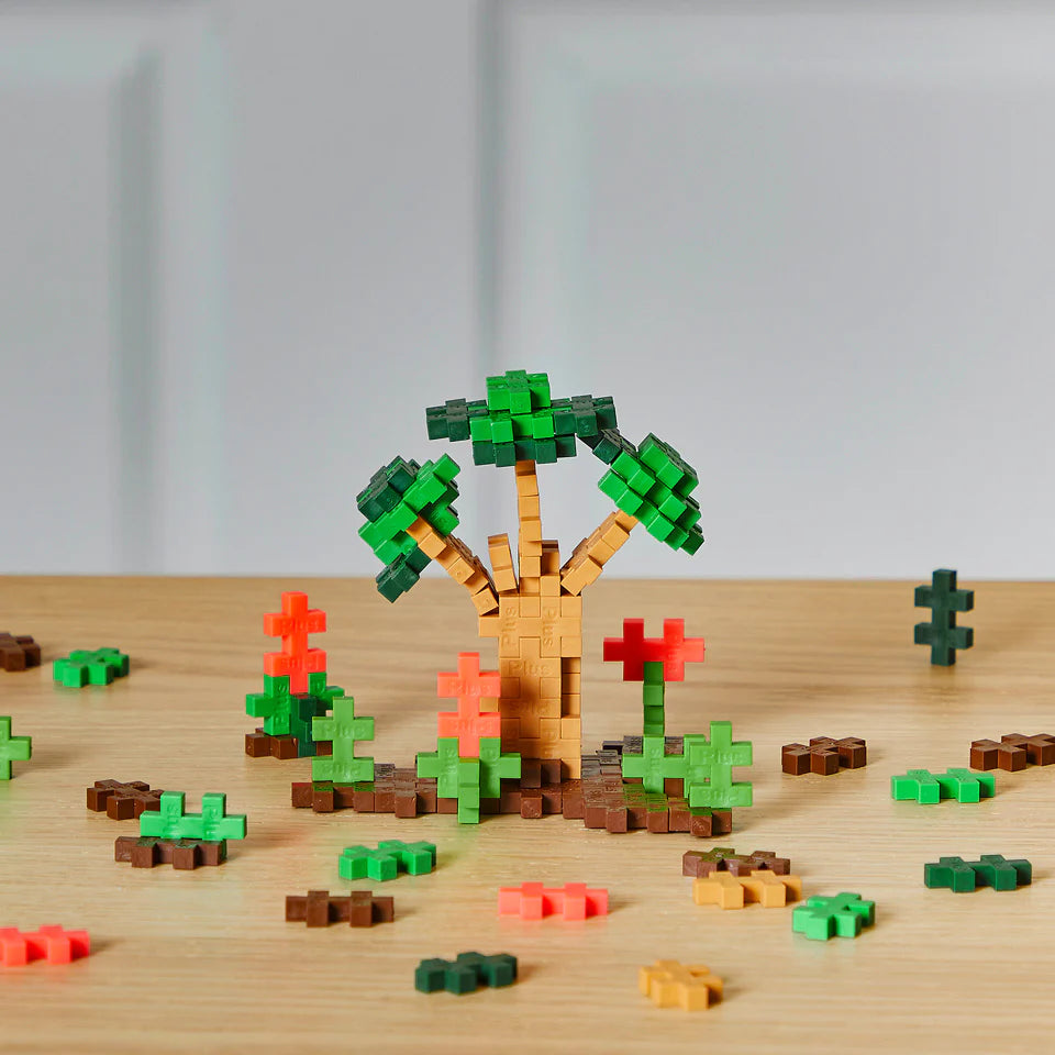Plus Plus Jungle 240pc colorful building pieces creating a 3D tree and plants on a wooden surface.