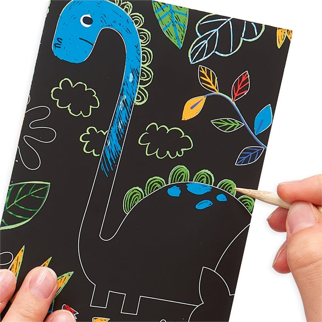 Scratch & Scribble Dino Days kids scratch art kit showing a hand revealing a colorful dinosaur design.