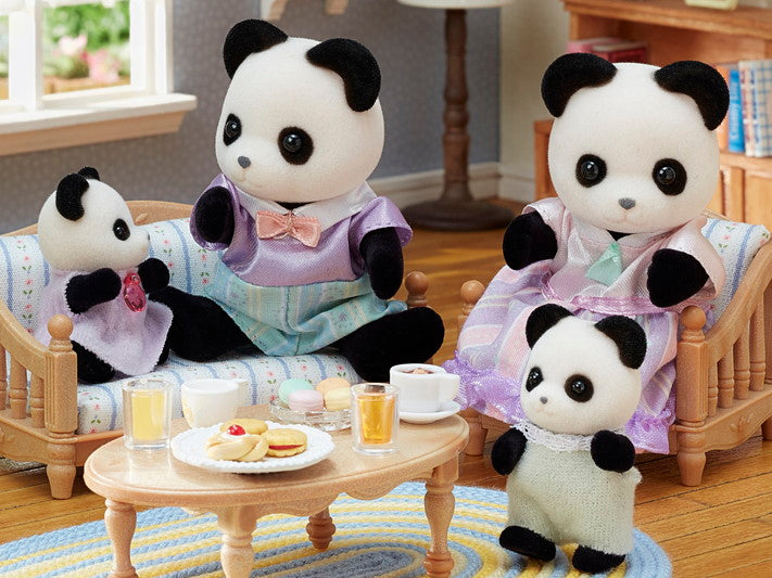 Pookie Panda Family four-piece set dressed in fabric clothes, posed in a cozy room with tea and snacks.