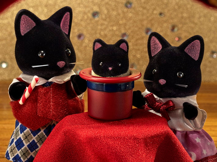 Midnight Cat Family figures with movable limbs, dressed in fabric clothes, featuring magic and playful poses on a red cloth table.