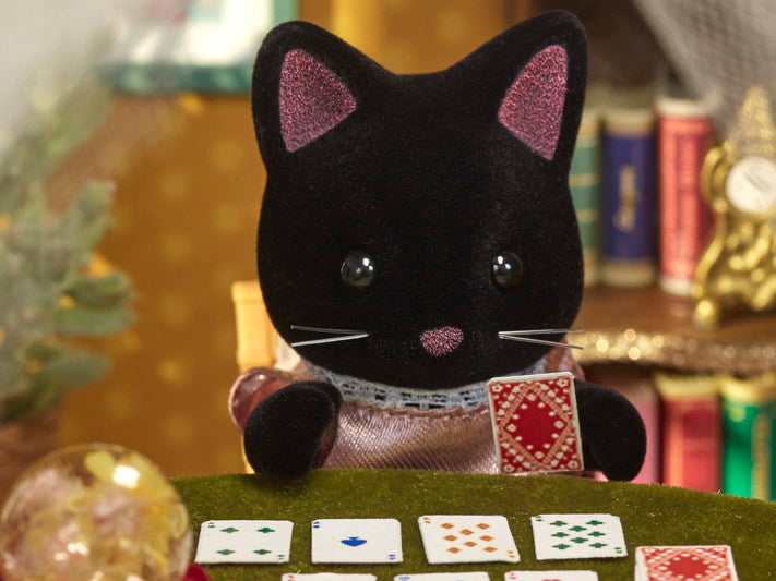 Midnight Cat Family figure with black fur playing cards, dressed in removable fabric clothing in a cozy room setting.