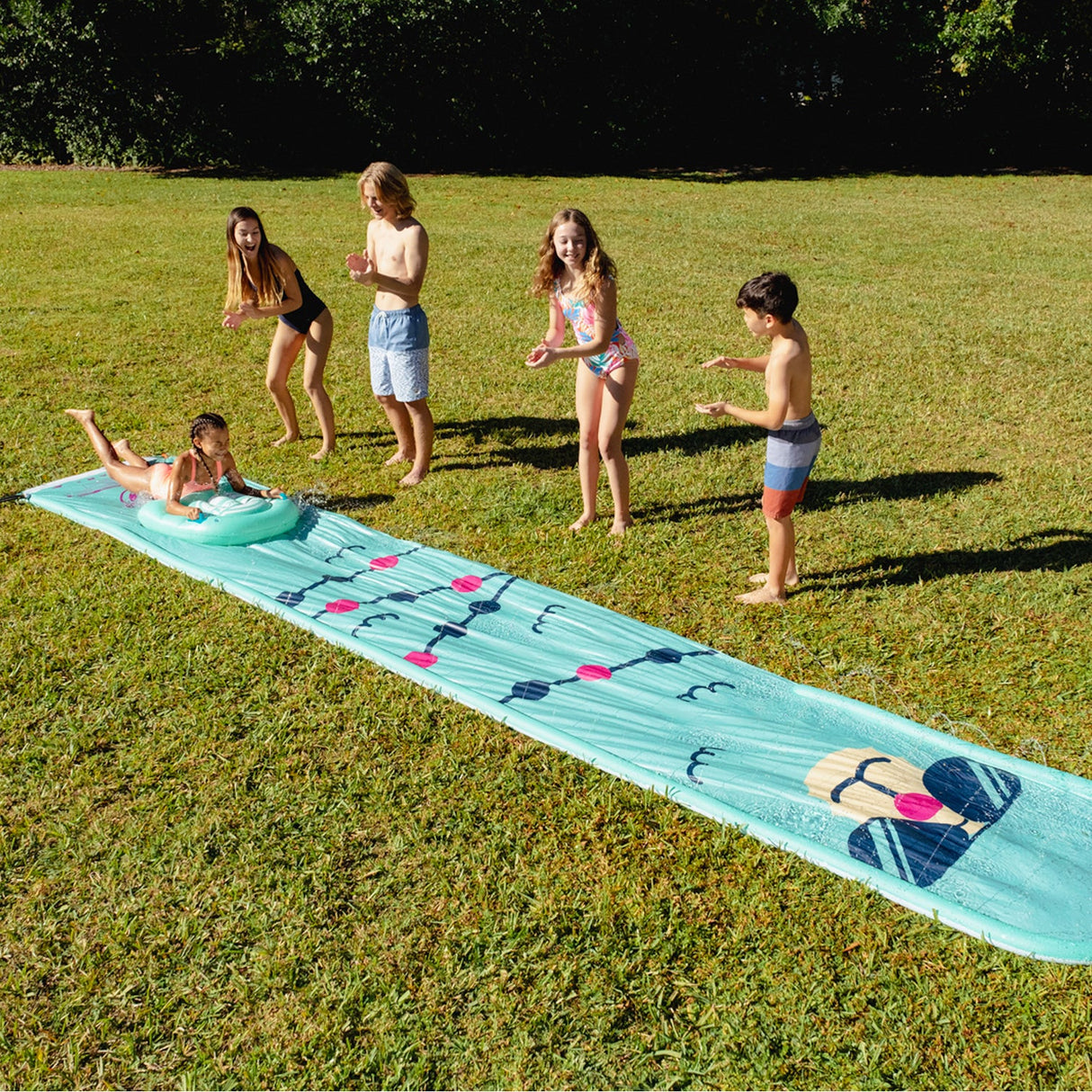 Children playing outdoors on the Splash Slide | Llama water slide with a matching bodyboard on green grass.