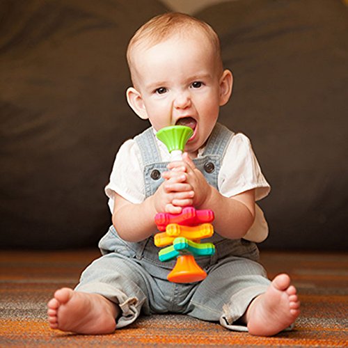Baby sitting and playing with colorful MiniSpinny sensory toy holding three vibrant propellers on corkscrew pole