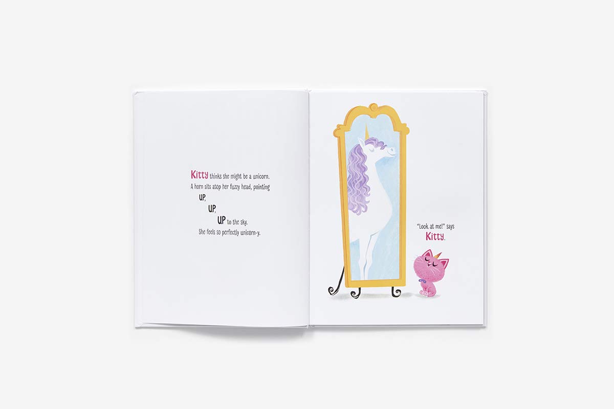 Itty Bitty Kitty Corn book open showing a pink kitten imagining itself as a unicorn in a mirror.