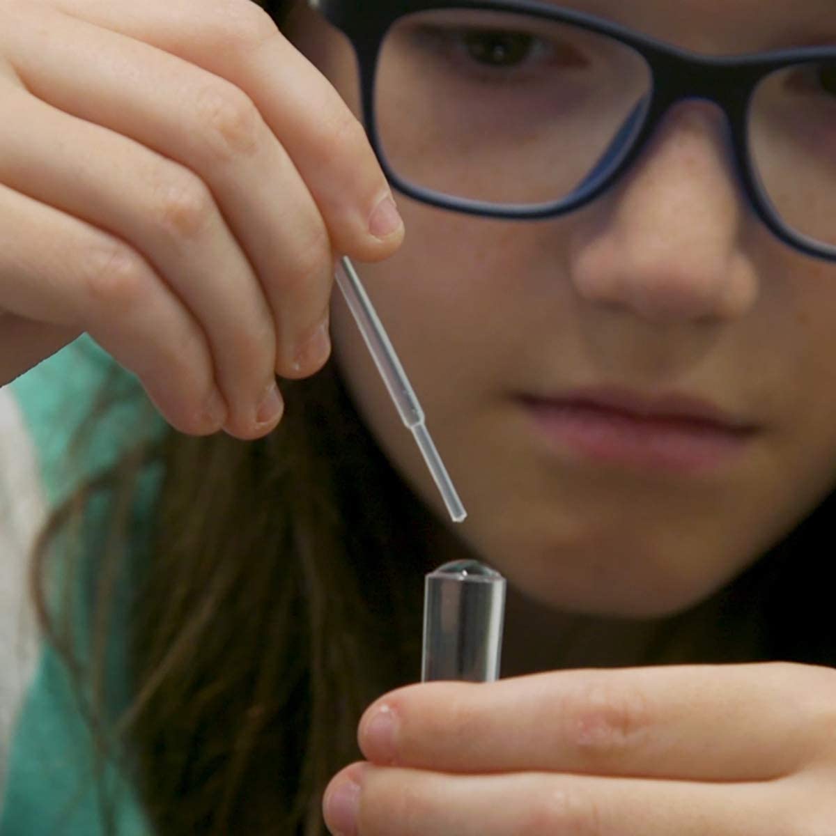 Child using a pipette and test tube from the Tiny Tools Tiny Science kit for hands-on experiments.