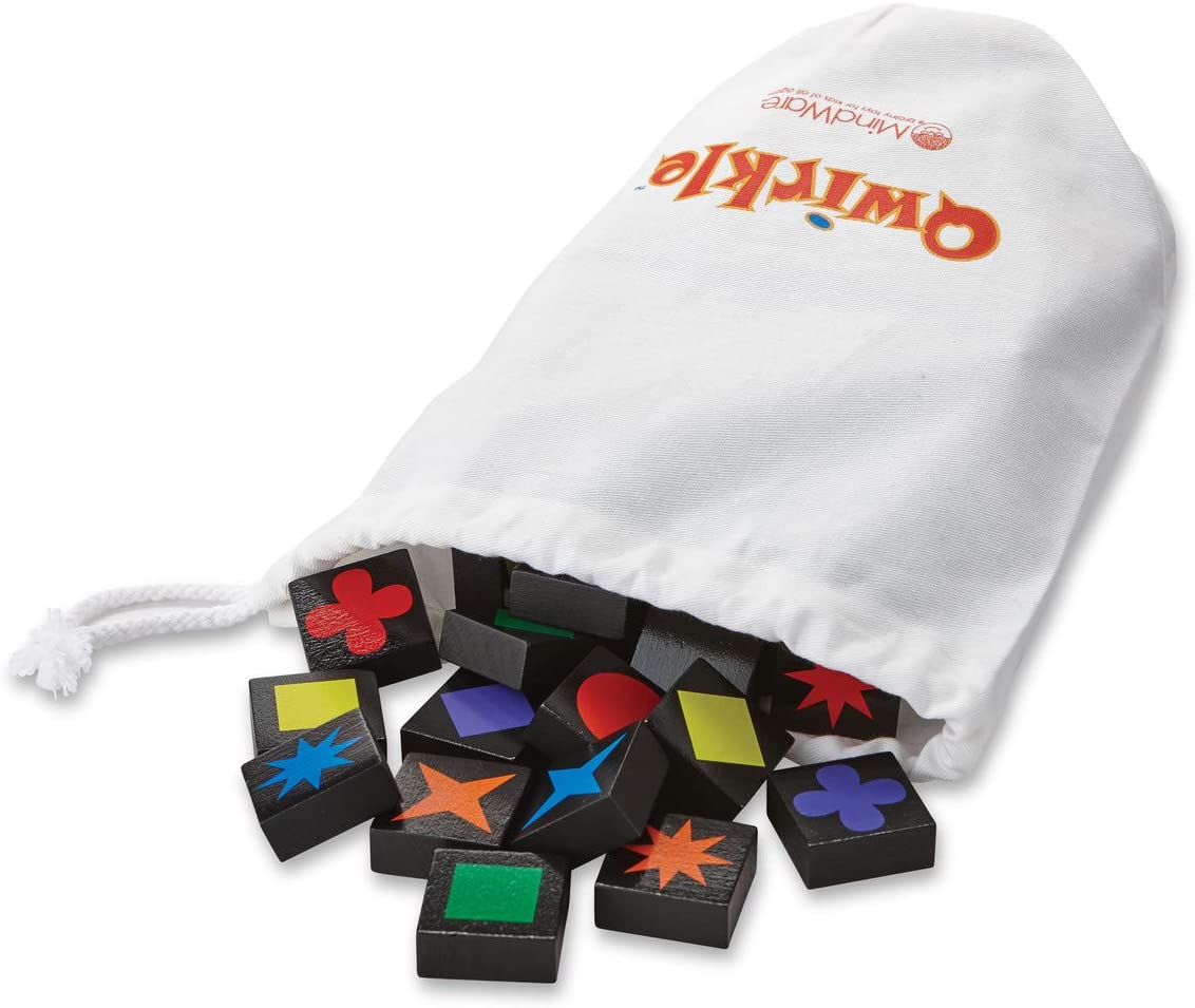Qwirkle game tiles spilling out of a white drawstring bag with colorful shapes and symbols on black wooden pieces.
