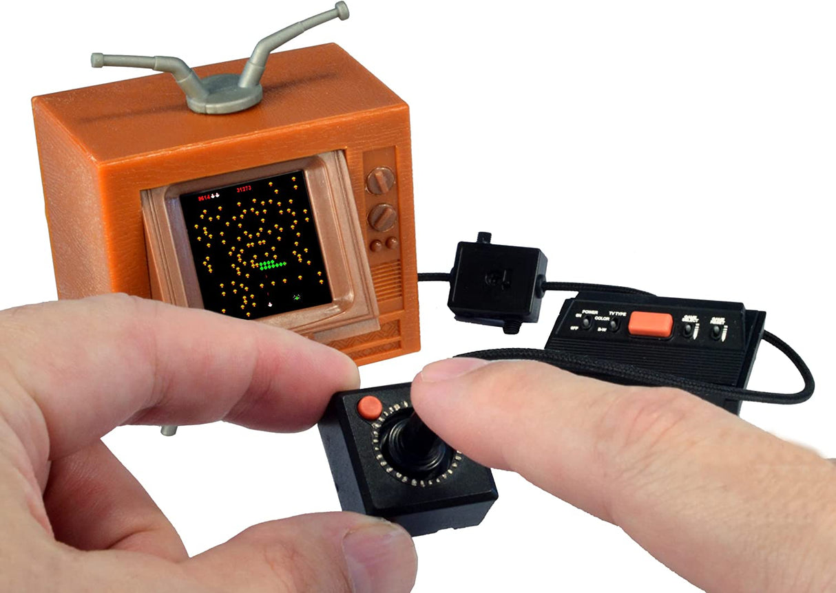 Atari Tiny! handheld retro console with 1.5-inch screen and joystick playing classic arcade games from 1978.