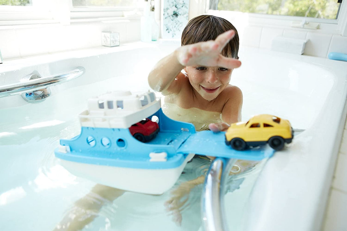 Child playing with the Ferry Boat toy in bathtub, featuring two-story design and slide-out ramp for cars.