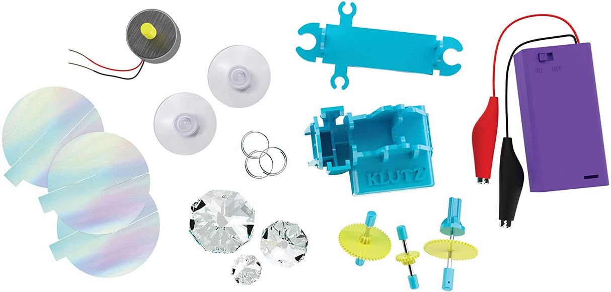 DIY Rainbow Catcher kit parts including gears, prisms, battery pack, and snap-together pieces for building a rainbow maker.