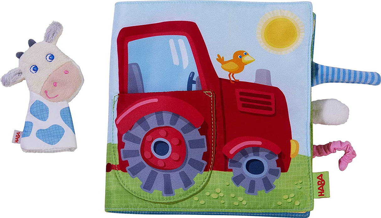 Down on the Farm Soft Book with Cow Puppet showing a colorful fabric book page with red tractor and attached cow finger puppet.