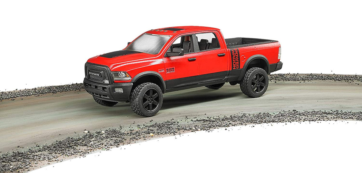 Red Ram 2500 Power Wagon toy truck with crew cab and detailed off-road design on a dirt trail.
