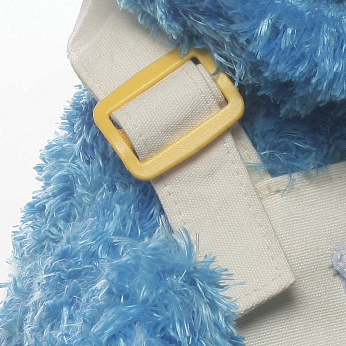 Close-up of blue fuzzy fabric and yellow buckle on the Teach-Me Cookie Monster plush from GUND Teach Me Collection.
