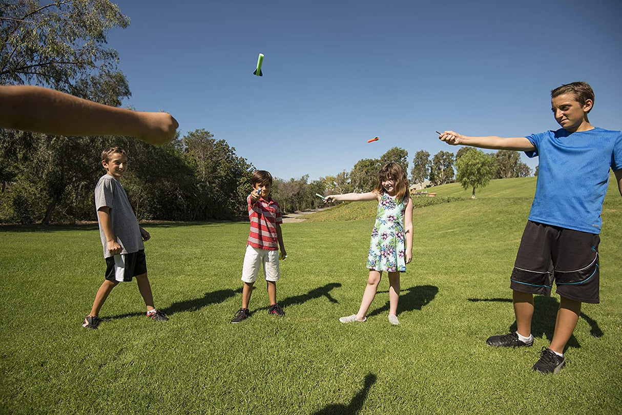 Kids outdoors playing and launching Squeeze Rockets flying from handheld squeeze launch bulbs on a sunny day.