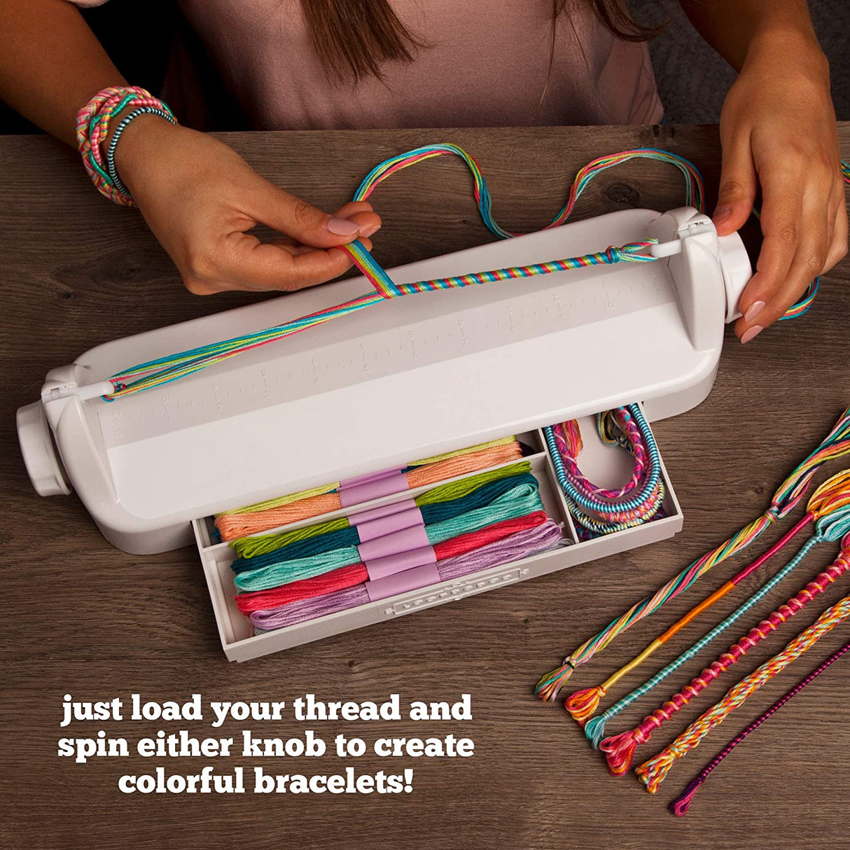 LoopdeDoo Friendship Bracelet Maker with colorful embroidery floss and handmade twisted bracelets on wooden table.