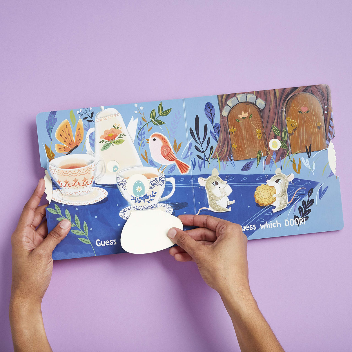 Hands open colorful interactive board book Eggs are Everywhere with flaps and playful illustrations for toddlers.