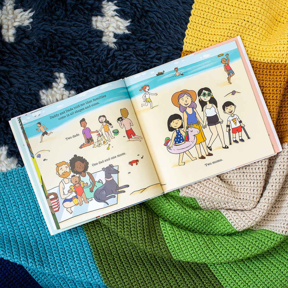 Open children's book Daddy & Dada showing diverse families on a colorful beach scene illustration.