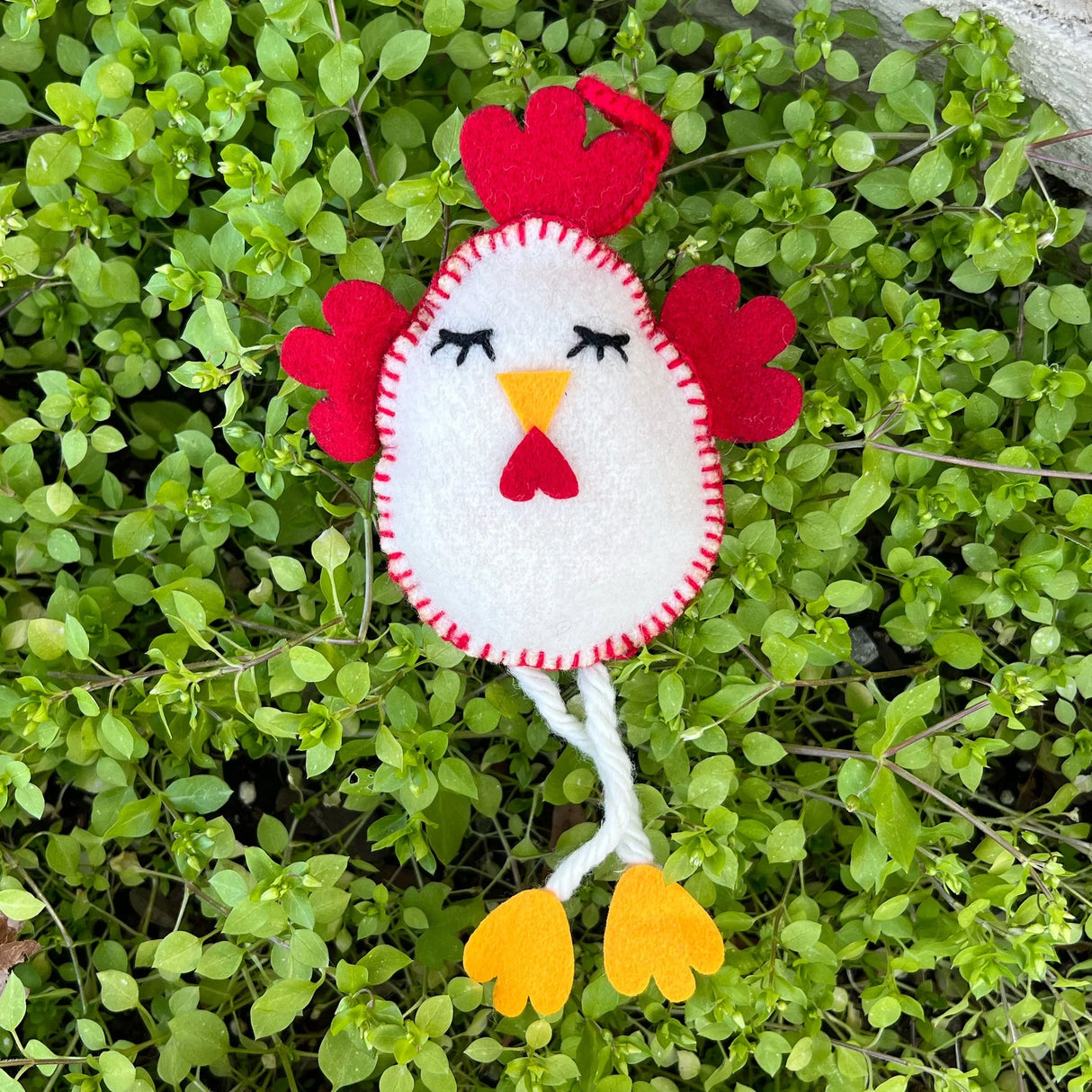 Chicken Felt Ornament handcrafted with white felt and red details, featuring dangling yellow feet on green leaves.