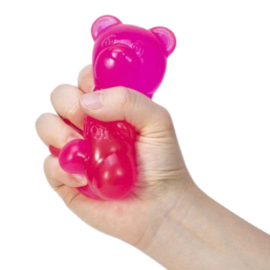 Hand squeezing a bright pink NeeDoh Gummy Bear fidget toy with groovy, squishy texture for stress relief.