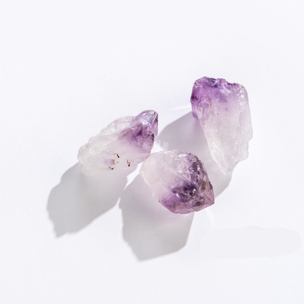 Three rough Amethyst Point stones with natural purple gradient on white background, 1 to 2 inches each.