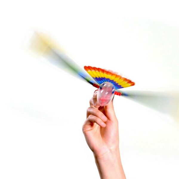 Hand holding the Tim Bird flying toy with colorful wings spinning mid-flight against a white background.