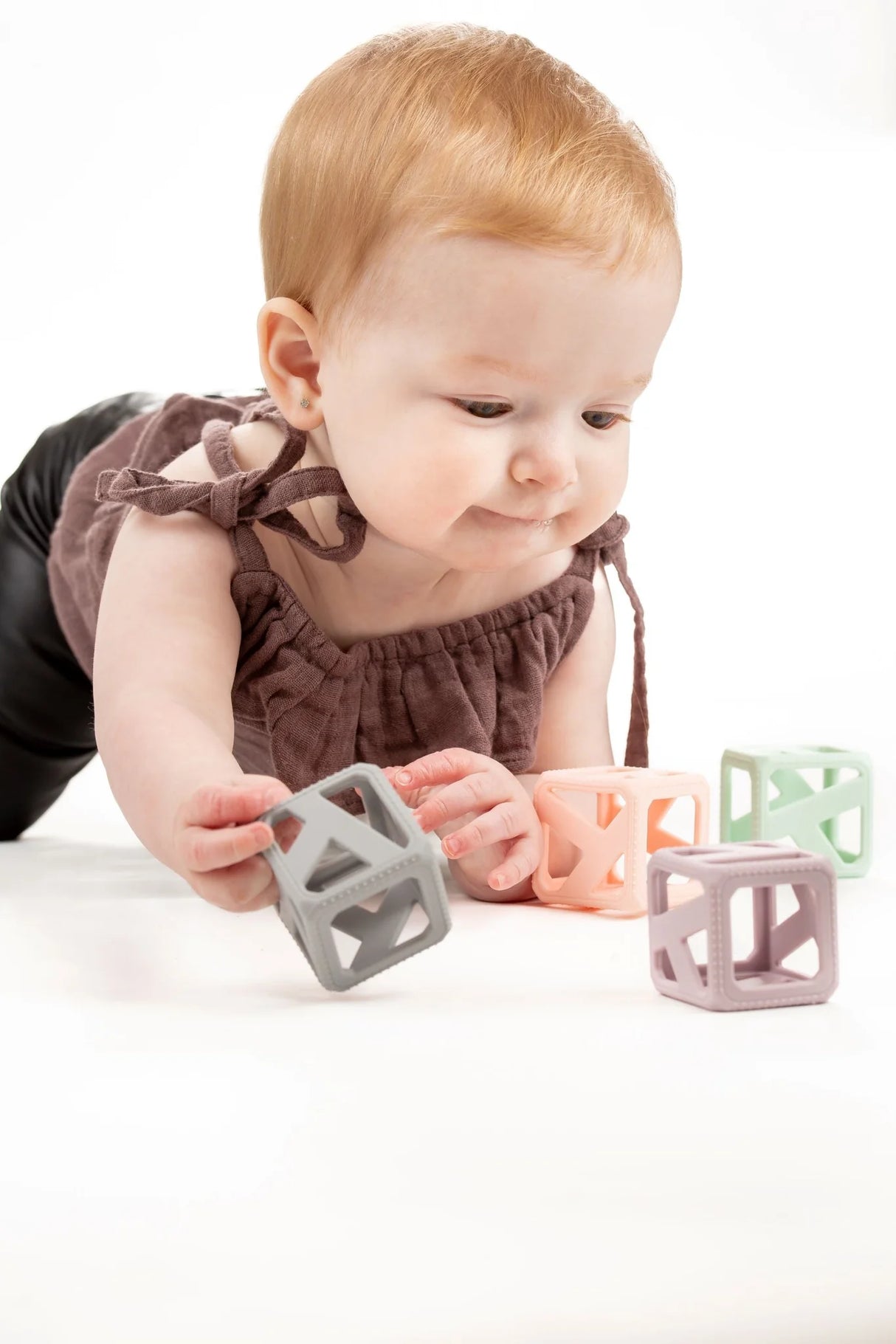 Baby playing with Stack & Chew Pastel Cubes, BPA-free silicone teething and stacking toy for infants.