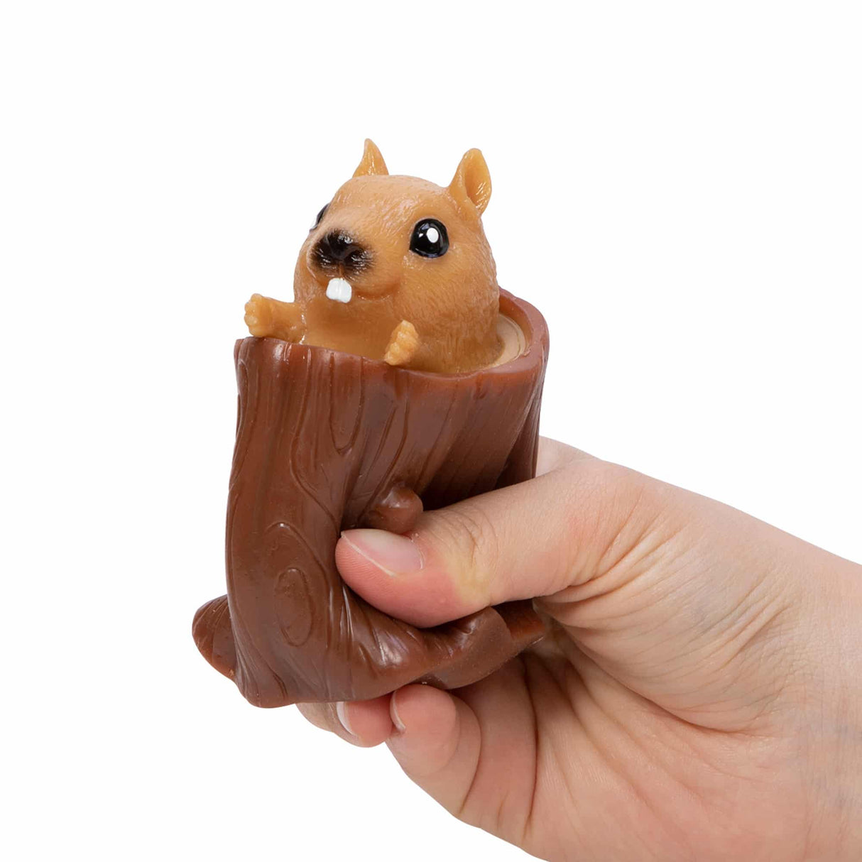 Hand squeezing Nutty Squirrel Popper toy with squirrel popping out of a tree log, playful and fun for kids.