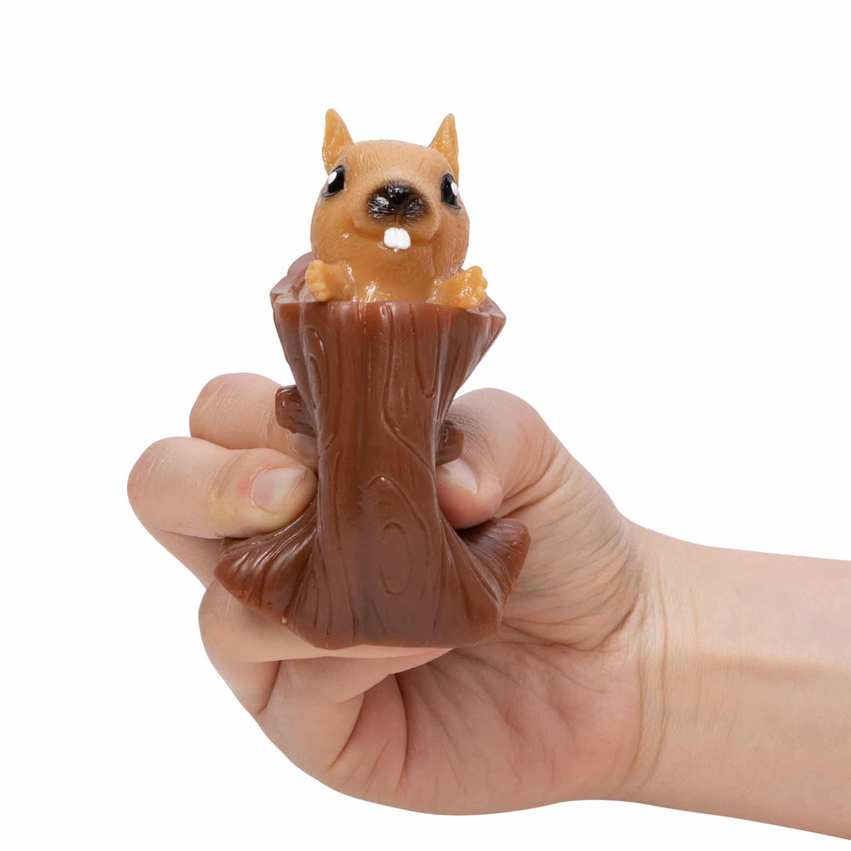 Hand squeezing the Nutty Squirrel Popper toy with the squirrel popping out of the tree log.