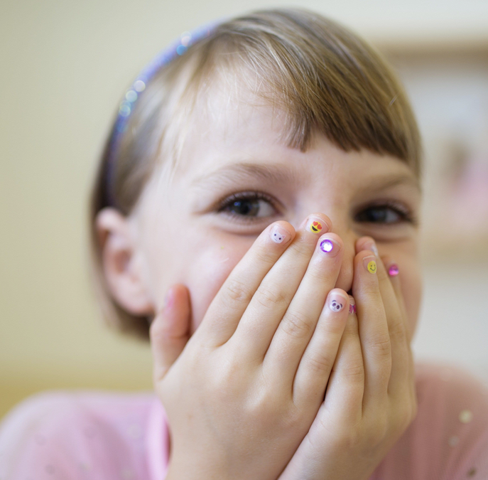 Close-up of a child showing nails decorated with Nail Stickers | Unicorns featuring colorful playful designs.
