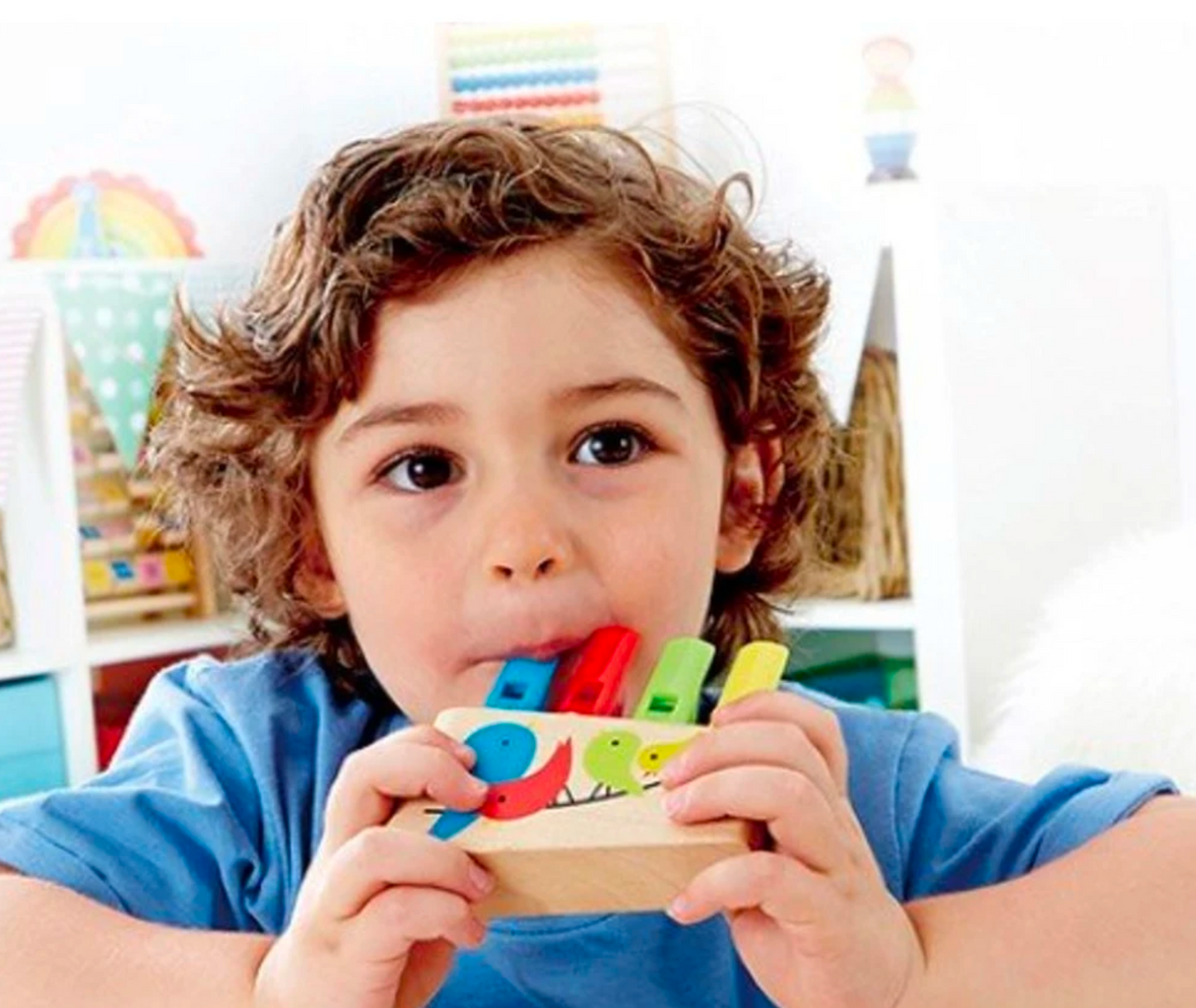 Child playing colorful 4-tube Pan Flute with bird design, encouraging musical exploration and creativity for kids.