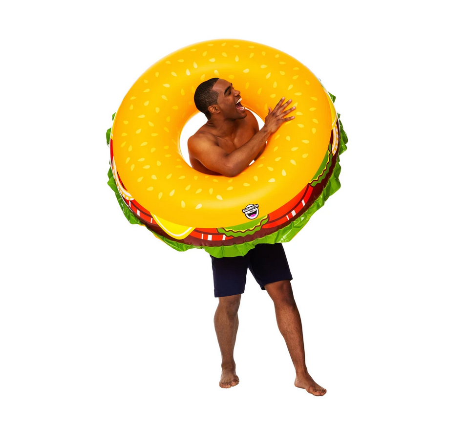 Man wearing and playing with a colorful Pool Float | Cheeseburger pool toy on white background.