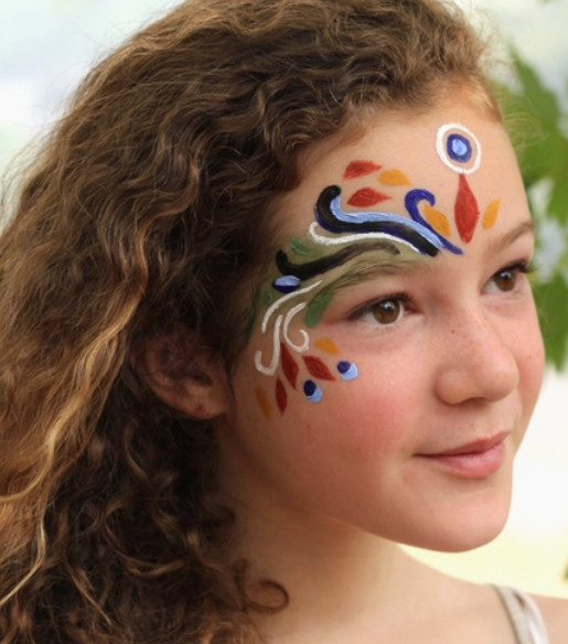Face Paint Kit - Natural showing a girl with colorful, intricate natural face paint design on her cheek and forehead.