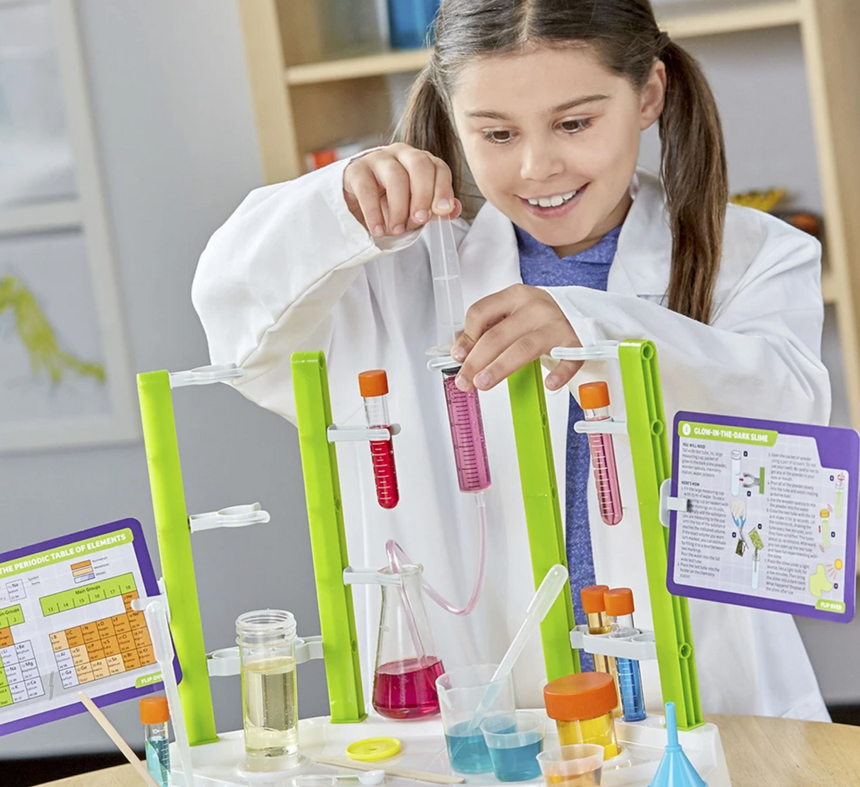 Child conducting colorful experiment with test tubes and lab equipment on the Ooze Labs Chemistry Station.