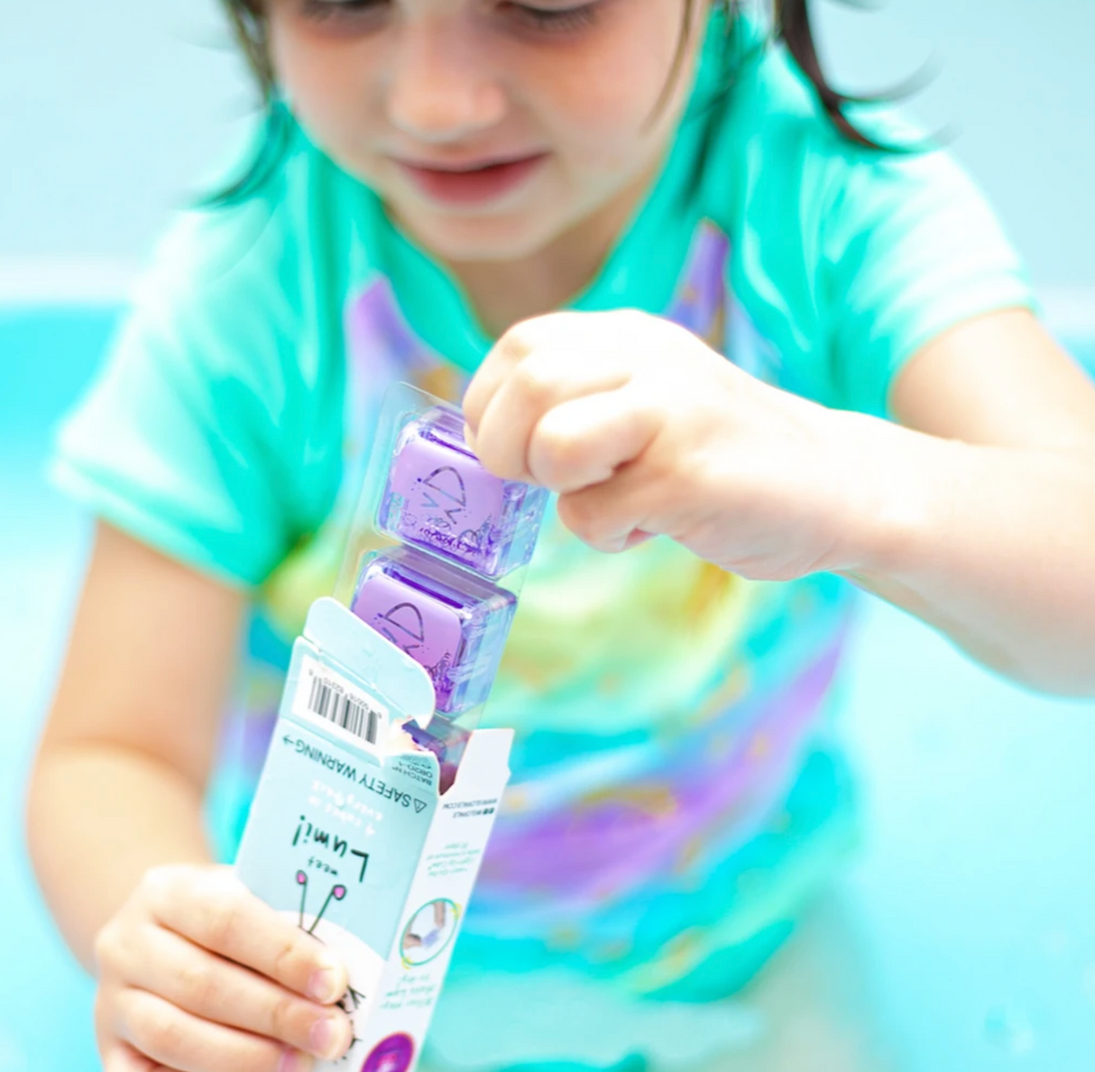 Child playing with Glo Pals Purple light-up cubes from the pack, showing bright purple glowing toys.