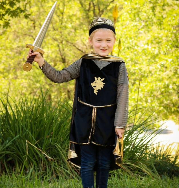 Child dressed as a knight holding the Gladius Long Dagger foam sword outdoors in a playful battle pose