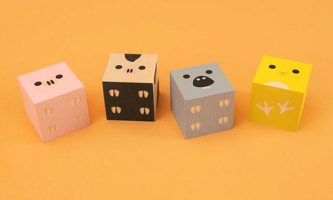 Cubelings Farm Blocks featuring four colorful sustainable wooden animal cubes: chick, cow, donkey, and pig on a yellow background.