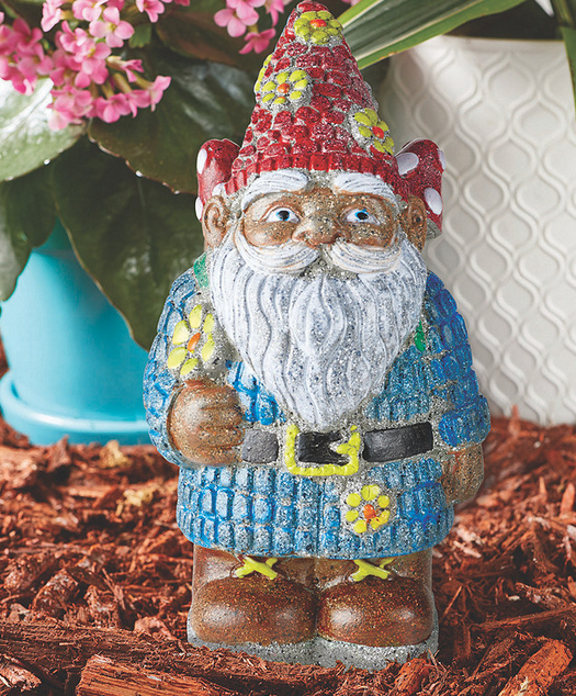 PYO Stone Gnome painted with red hat and blue coat standing on mulch with flowers and leaves behind.