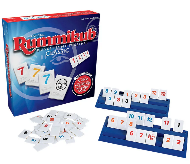 Rummikub game set with numbered tiles in different colors on racks and box showing classic edition packaging.