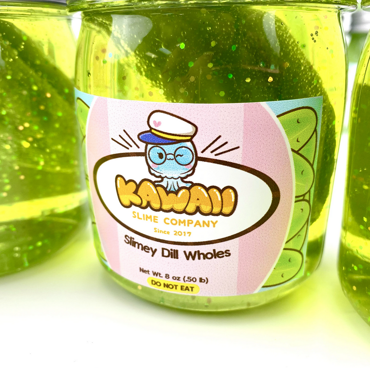 Shimmery Pickle Clear Slime in a jar with green glittery slime and playful label from Kawaii Slime Company.