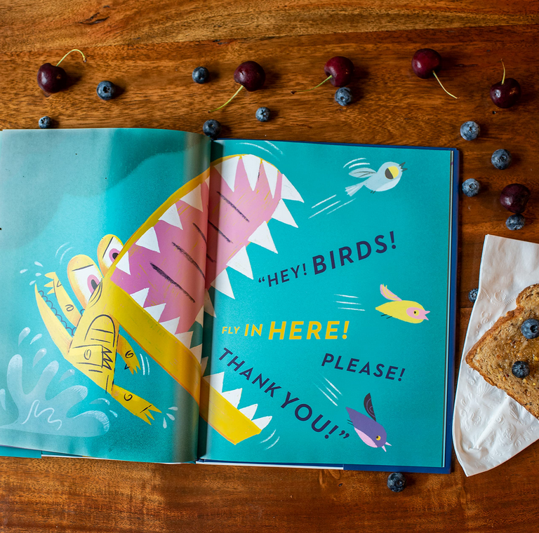 Open children's book "Chez Bob" showing colorful alligator and birds with text inviting birds to fly in.