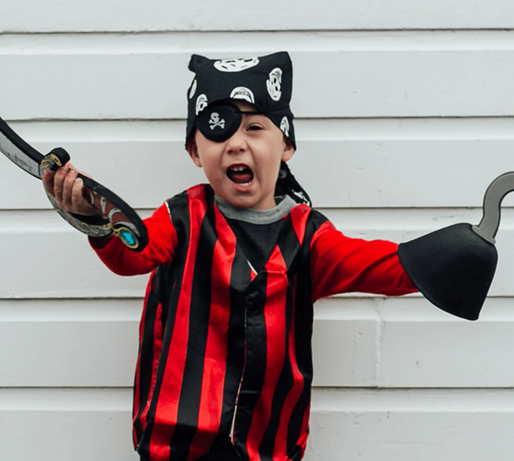 Child dressed as a pirate wearing a Pirate Eye Patch, red and black striped shirt, and pirate accessories for play.