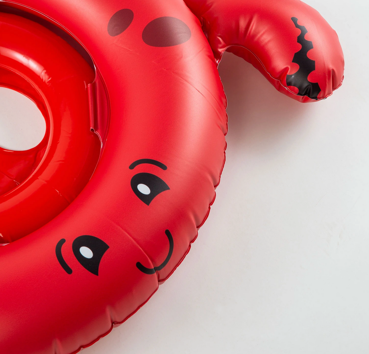 Close-up of the red Lil Float | Crab baby float with happy face and comfy leg openings for toddlers.