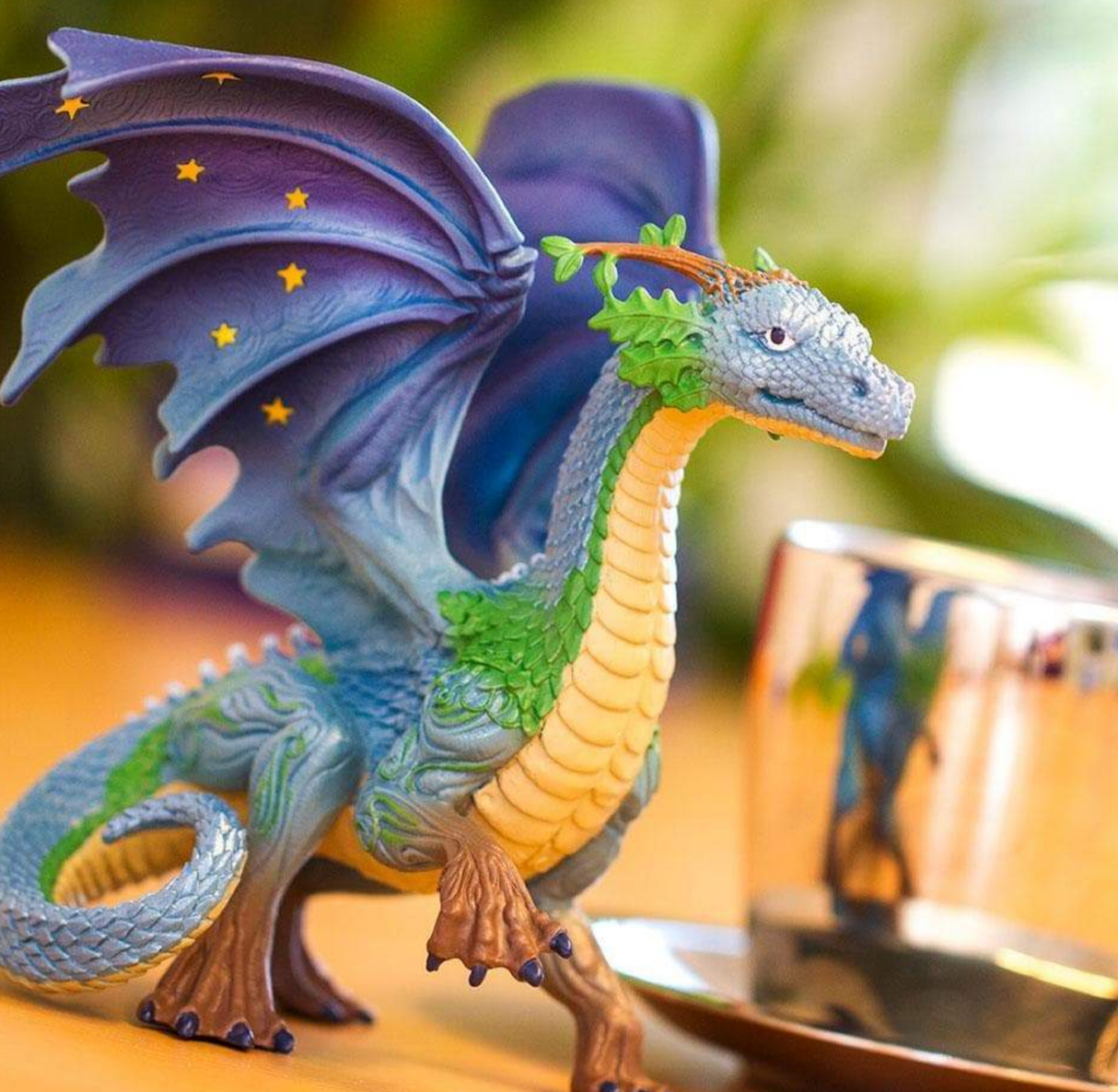 Earth Dragon hand-painted figure with pearlescent blue-green scales, yellow star-accented wings, and tree-like horns.