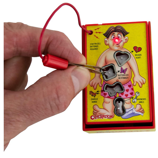 Hand holding tweezers playing World's Smallest Operation tabletop game with light-up buzzer nose.
