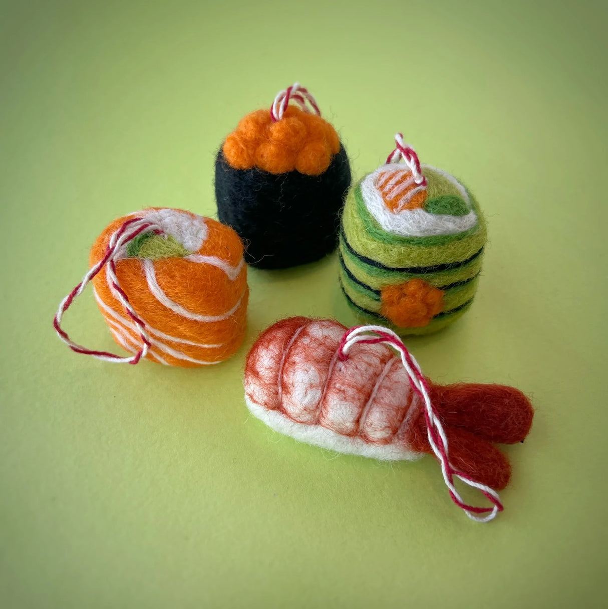Sushi Felt Ornament set with four colorful handmade felt sushi pieces on a light green background.