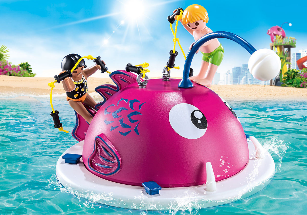 Family Fun | Swimming Island with two children climbing and playing on a pink fish-shaped floating toy in the water.